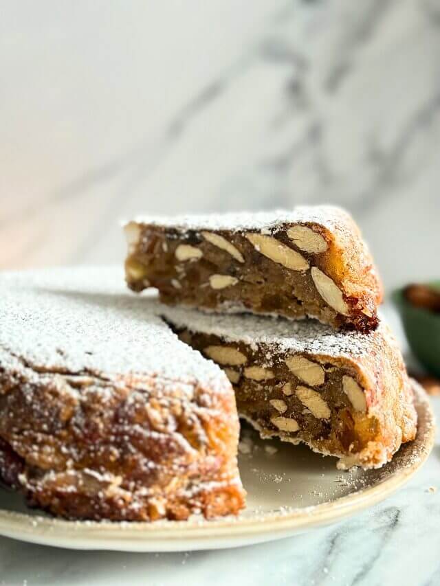 close up of panforte with a slice on top, on a plate